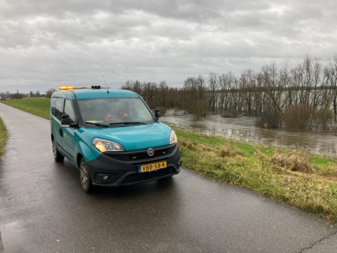 Auto van het waterschap op de dijk