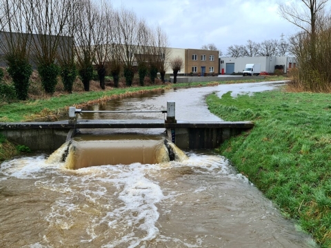 Een stuw in een watergang met kolkend water