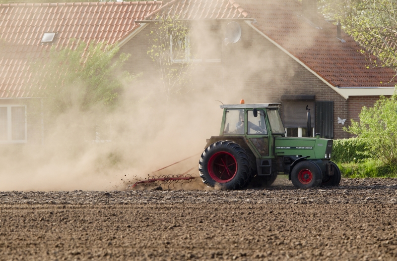 boer is bezig op het land met tekker